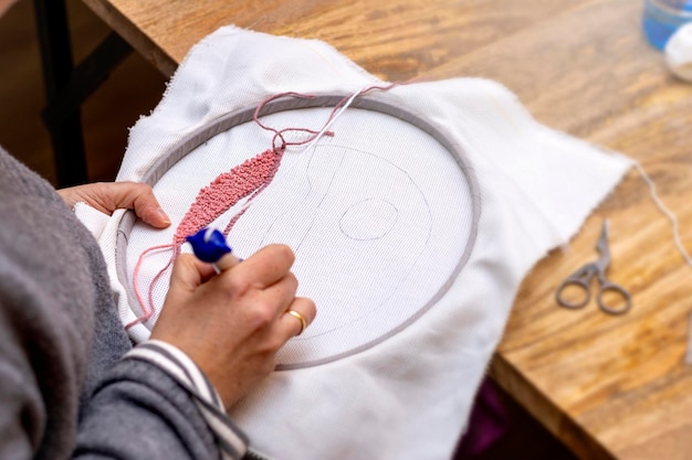 osoba haftująca w pracowni
